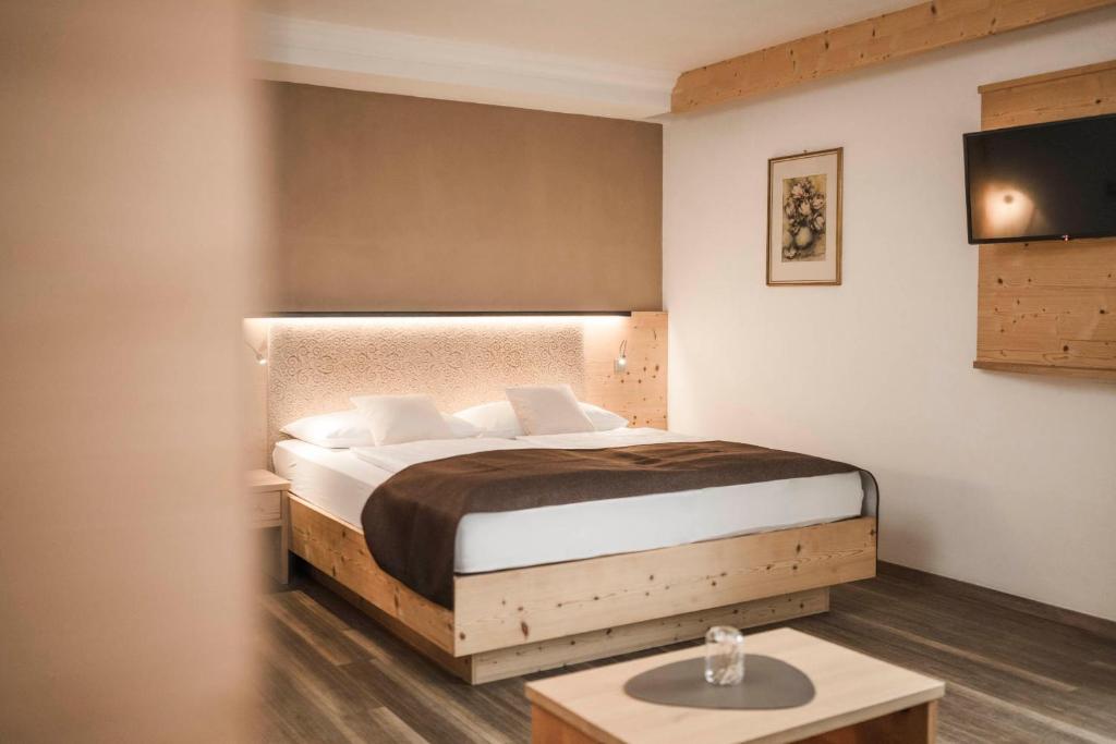 - une chambre avec un lit et une table dans l'établissement Hotel Karin, à Tirolo