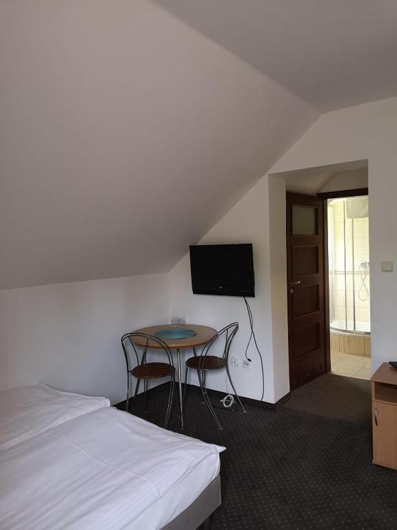 Cozy room with bed, TV, and small table; simple and functional.