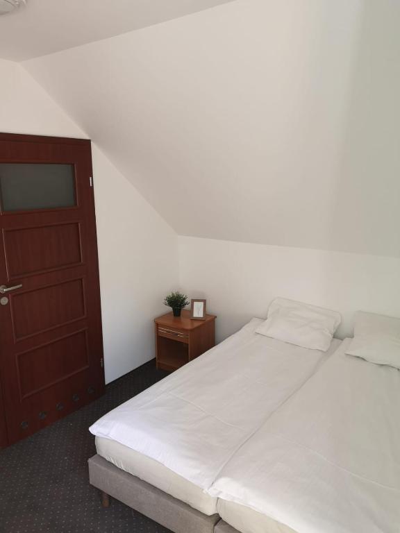 Simple bedroom with double bed and wooden door.