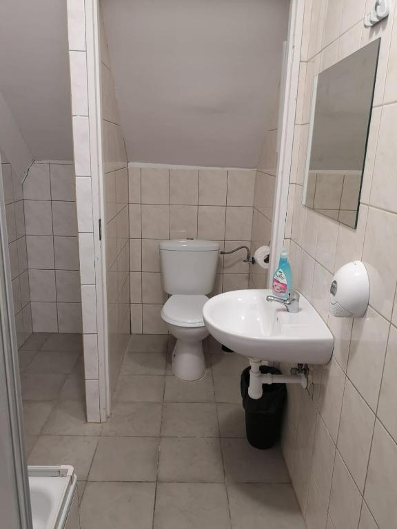 Bathroom with toilet, sink, and tiled floor.