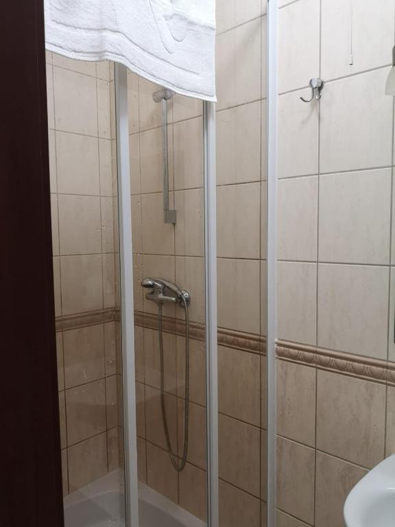 Compact shower area with glass doors and tiled walls.
