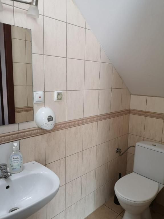 Bathroom with tiled walls, sink, and toilet.