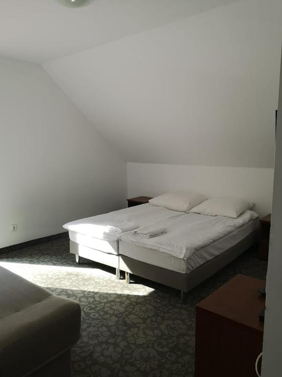 Minimalist room with double bed and soft lighting; calm and restful.