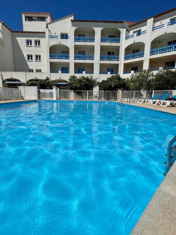 une grande piscine devant un immeuble dans l'établissement Le Bleu Soleil de Barcarès, au Barcarès