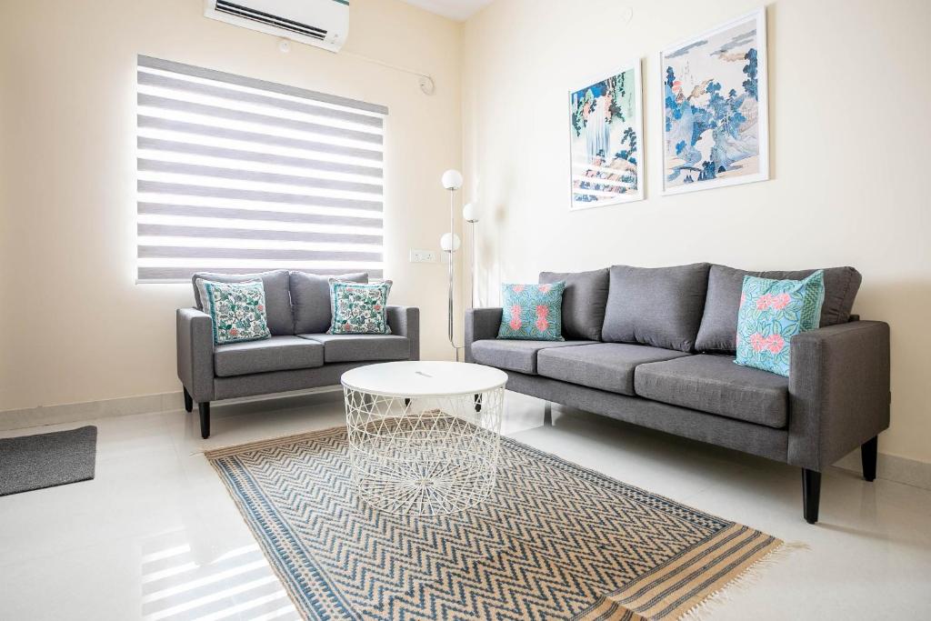 a living room with two couches and a table at MyHaus Apartments in Hyderabad