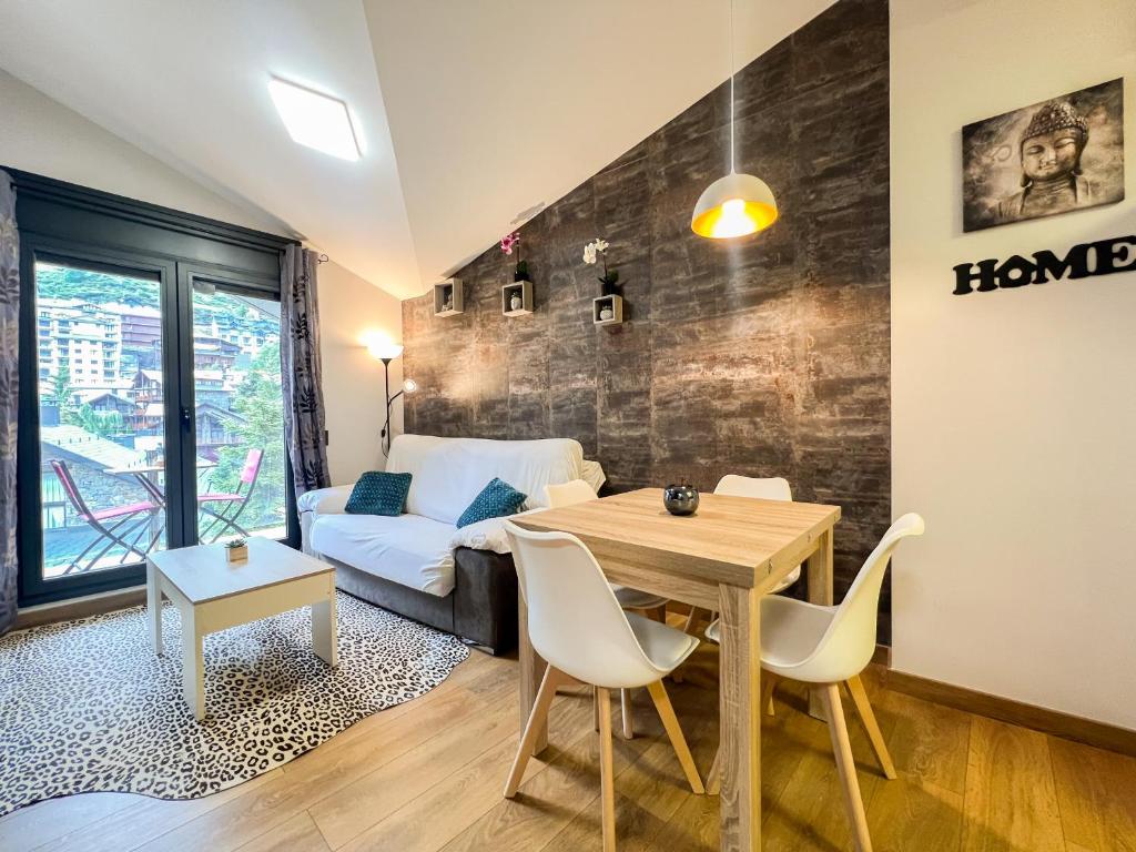 uma sala de estar com uma mesa e um sofá em Apartamento moderno BH VALIRA en el Tarter, vistas em El Tarter