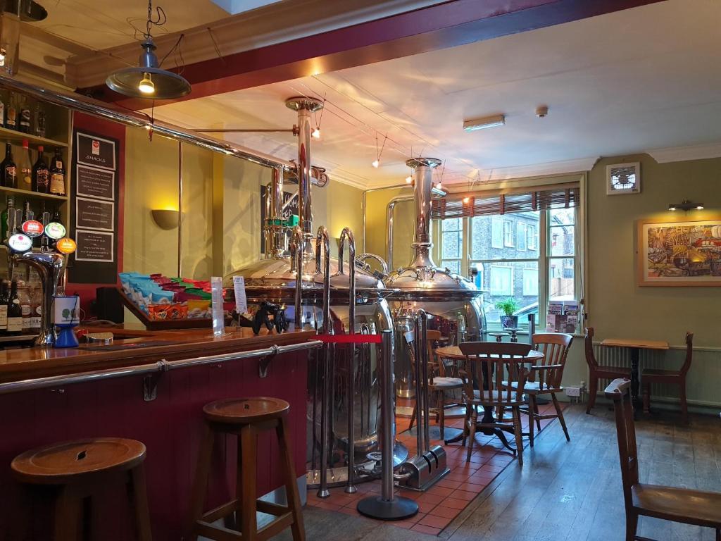 a bar with tables and chairs in a restaurant at The Old Cannon Brewery in Bury Saint Edmunds