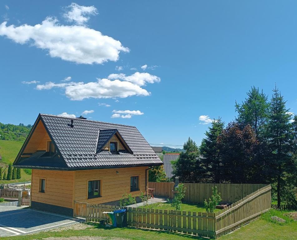 una casa con techo negro y valla en Nowy domek w Pieninach, en Grywałd