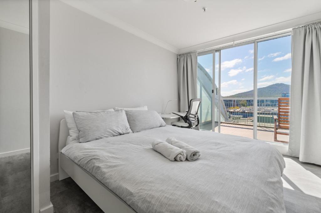 a bedroom with a white bed with a large window at Spacious Ensuite Room in a City Centre Duplex Apartment-2 in Canberra