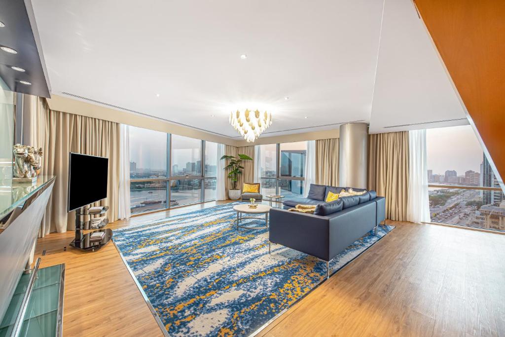 a living room with a couch and a television at Golden Sands Boutique Hotel-Dubai Creek in Dubai