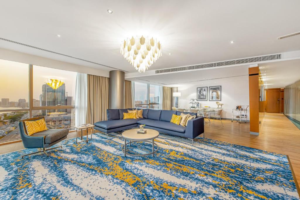 a living room with a blue couch and a table at Golden Sands Boutique Hotel-Dubai Creek in Dubai