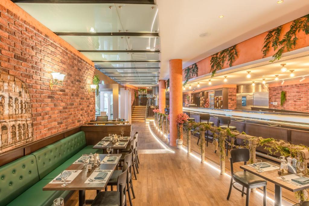 a restaurant with tables and chairs and a brick wall at Golden Sands Boutique Hotel-Dubai Creek in Dubai
