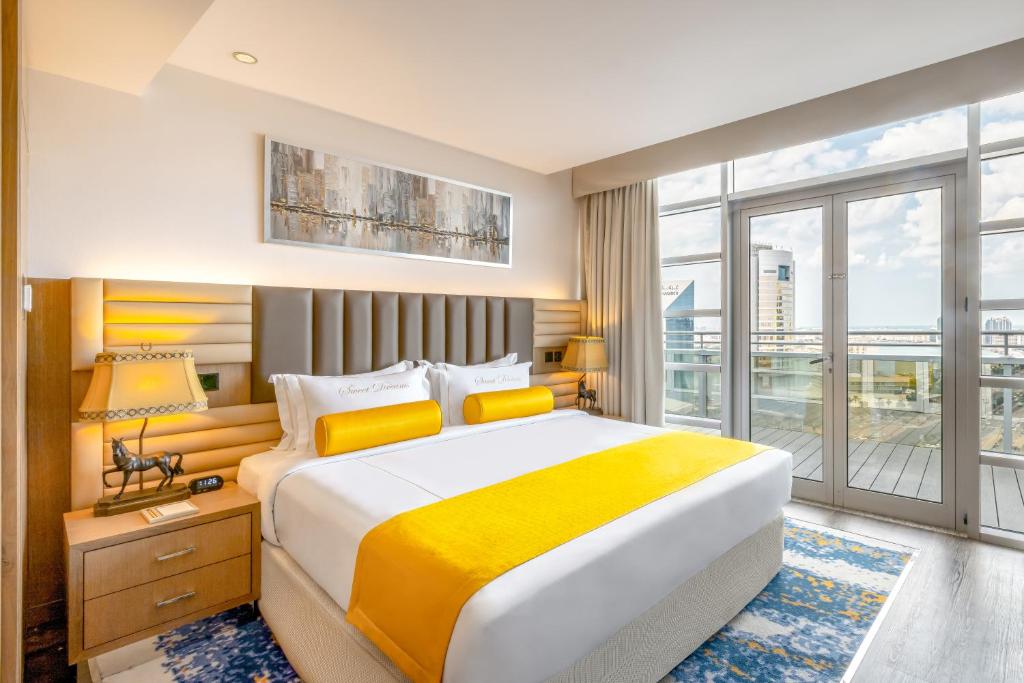 a bedroom with a large bed and a large window at Golden Sands Boutique Hotel-Dubai Creek in Dubai