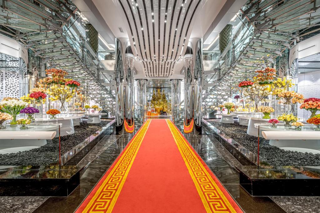 Pasillo de moqueta roja con flores en un edificio en Golden Sands Boutique Hotel-Dubai Creek, en Dubái