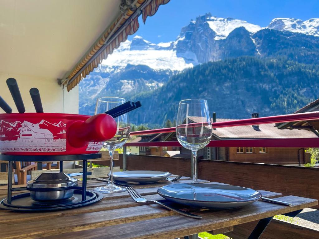 a table with glasses of wine on top of a mountain at Swiss Alps Lodge in Kandersteg
