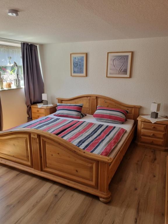 a bedroom with a large wooden bed with two pillows at idylische Ferienwohnung in Schollbrunn