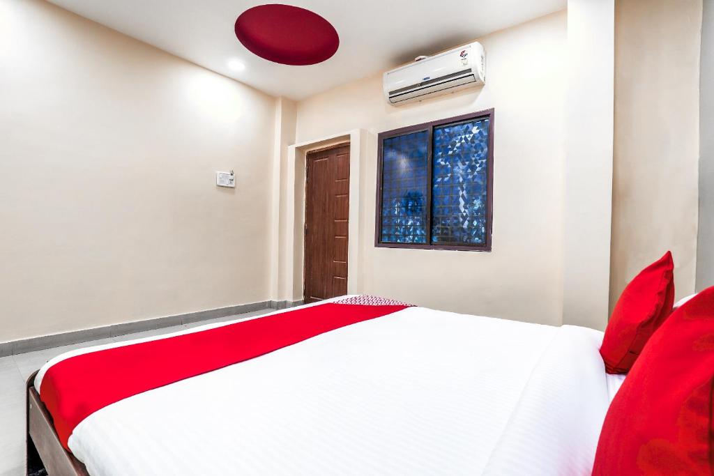 een slaapkamer met een wit bed en een raam bij OYO Flagship Sathya Inn in Warangal