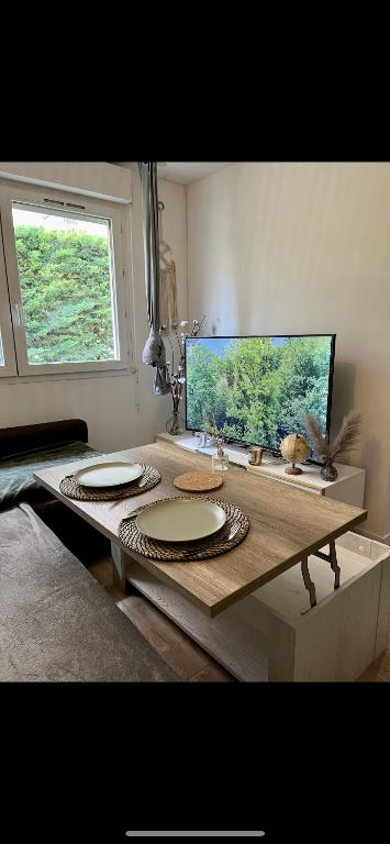 - une table avec des assiettes dans une chambre avec une fenêtre dans l'établissement Appartement 2 pièces Fabron, à Nice
