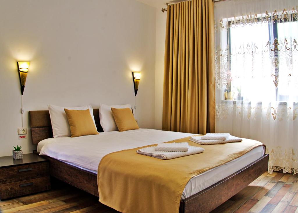a bedroom with a large bed with towels on it at CĂSUȚA LUI ION in Sulina