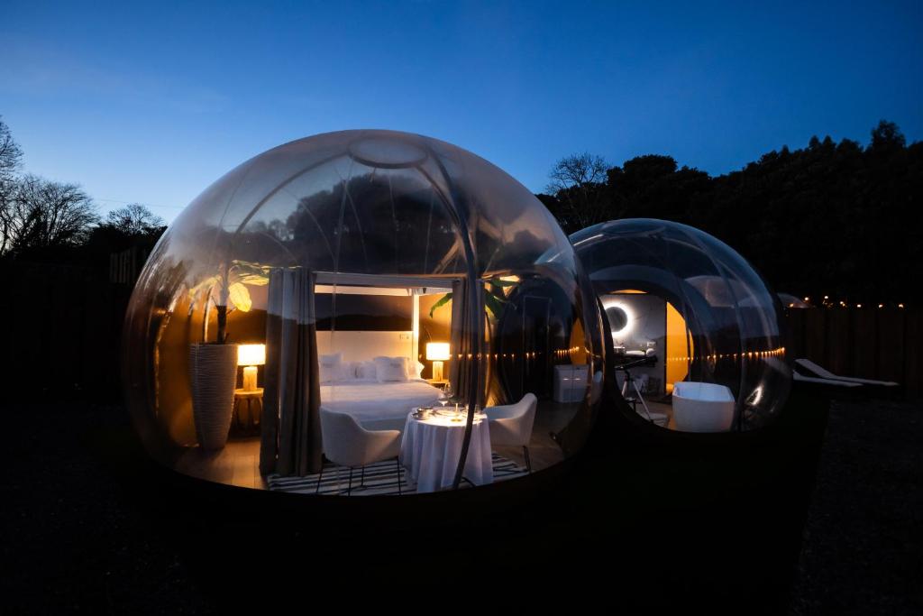 Deux dômes en verre avec un lit et une chambre dans l'établissement burbujas del sella, à Collera