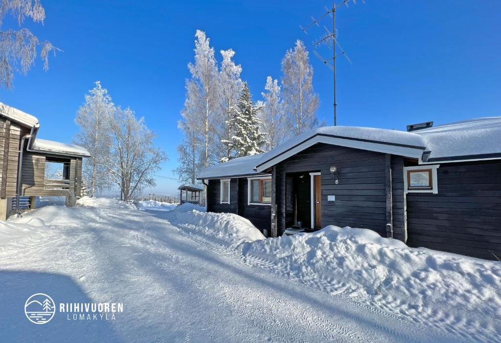 a house covered in snow next to a driveway at Lomariihi 8 in Muurame
