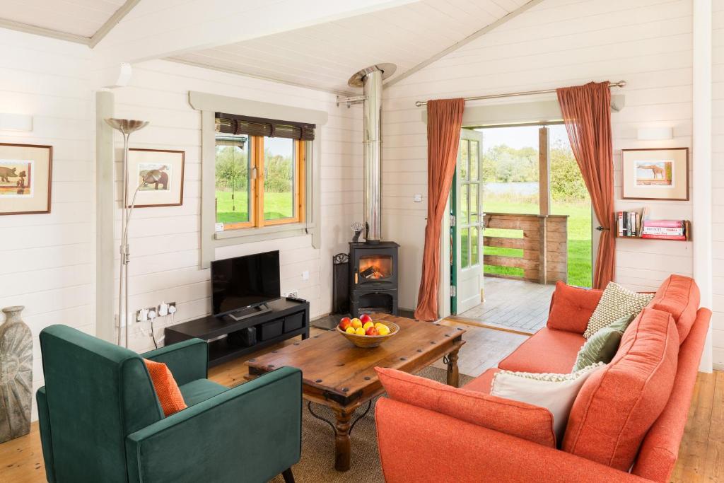 a living room with two chairs and a table at Iris Lodge, with cosy Log Burner 