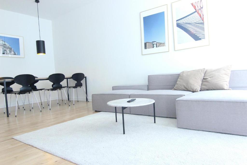 Wonderful 2-bed in Frederiksberg C في كوبنهاغن: غرفة معيشة مع أريكة وطاولة