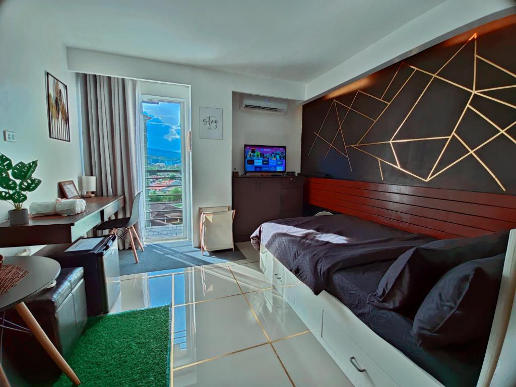 Dormitorio con cama, escritorio y TV en Elevate at 902 - Cityscape Tower Condominium - with Netflix, Near SM, Ayala, IT Park en Mandaue City