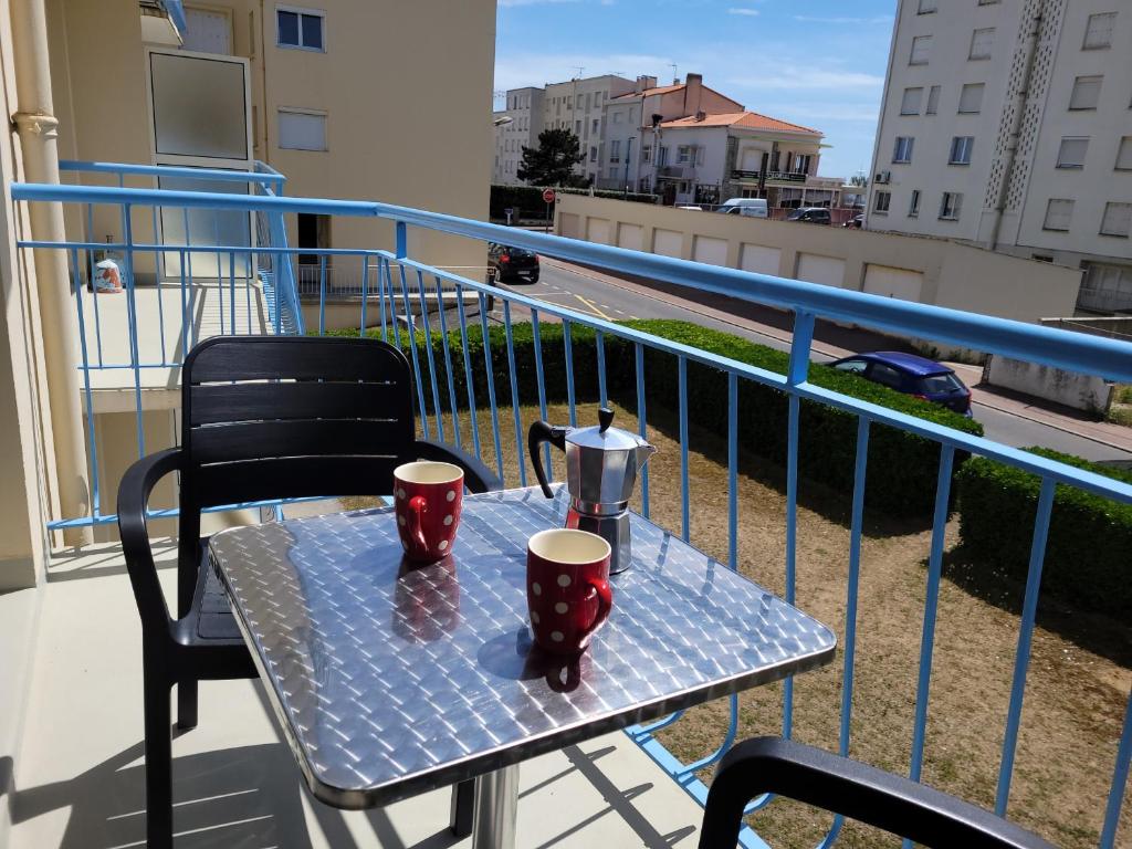 - une table avec deux tasses à café sur un balcon dans l'établissement Les Pampres, à Saint-Jean-de-Monts