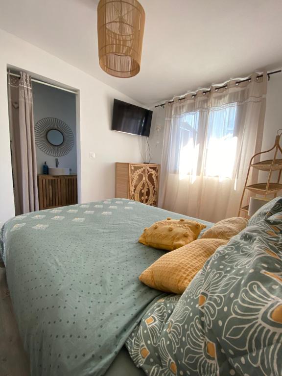 a bedroom with a bed with pillows on it at Le bungalov' ,une pause dans le sud sauvage in Petite Île