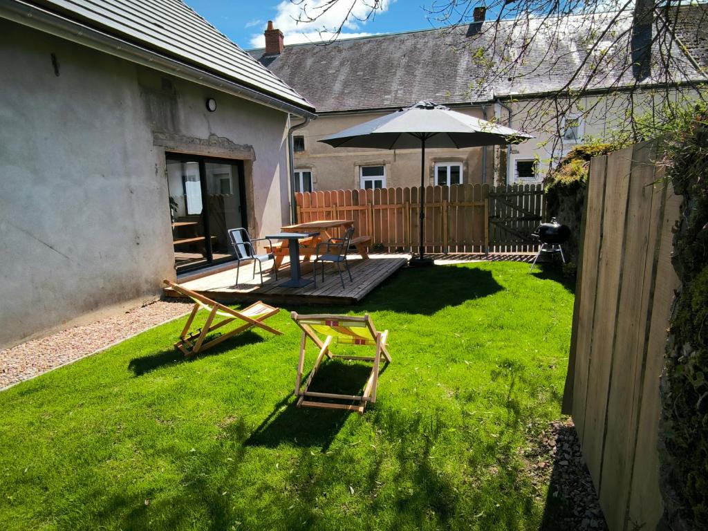 a backyard with a table and an umbrella at Maison Valette in Roussillon-en-Morvan