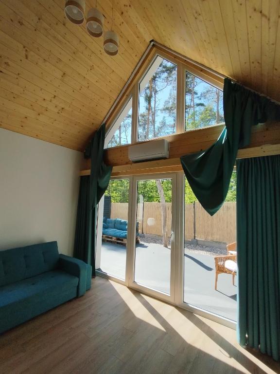 a living room with a couch and a large window at Stania Scandinavian CENTRUM in Boszkowo-Letnisko