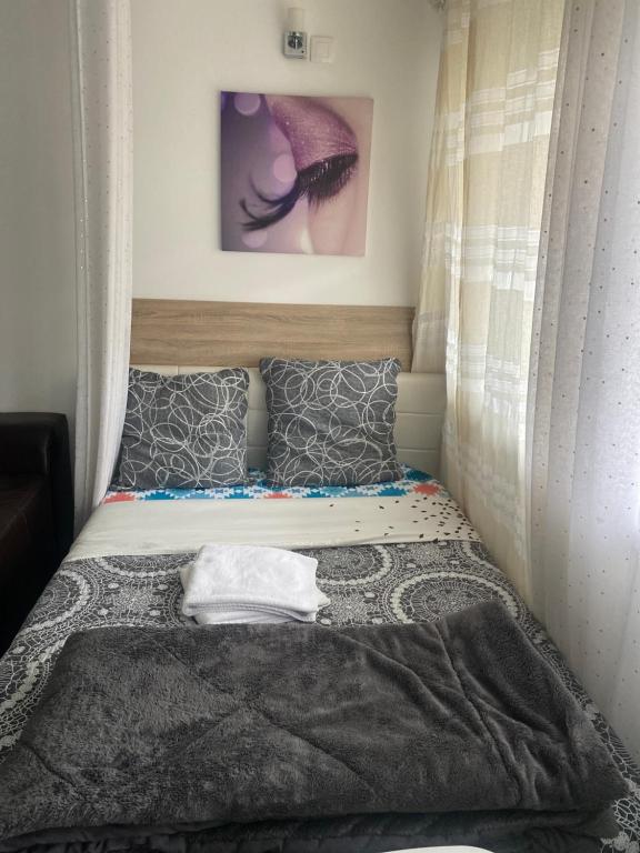 - un lit dans une petite chambre avec une photo sur le mur dans l'établissement Résidence Zola, à Villeurbanne