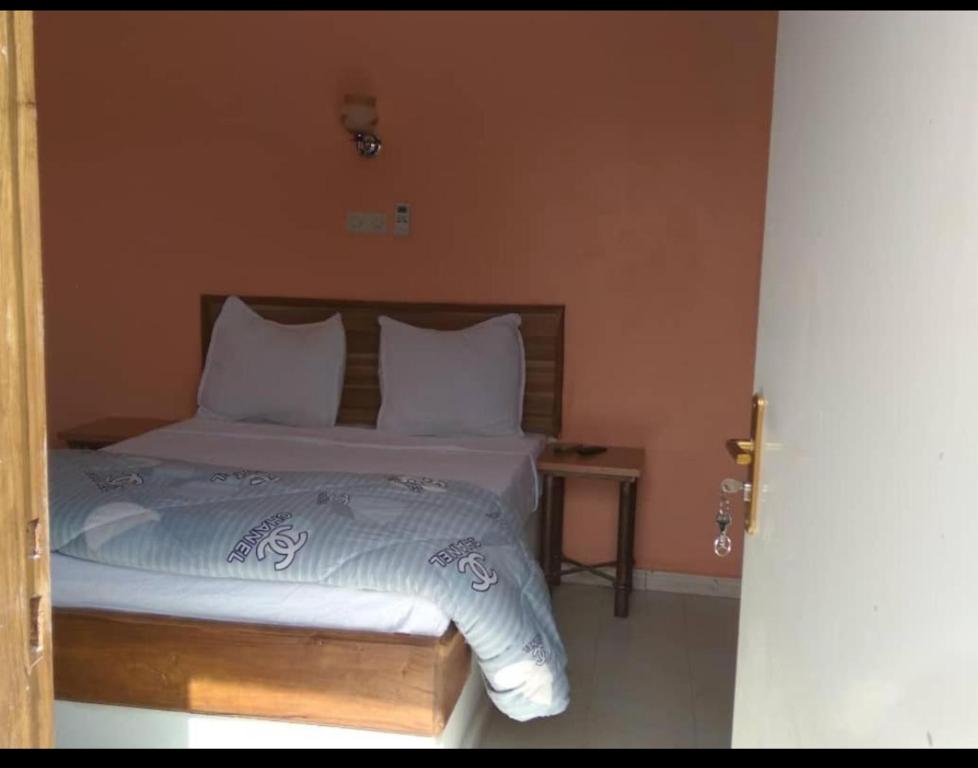 a bedroom with a bed with white sheets and pillows at Hotel Al Khayatt in Kaolack
