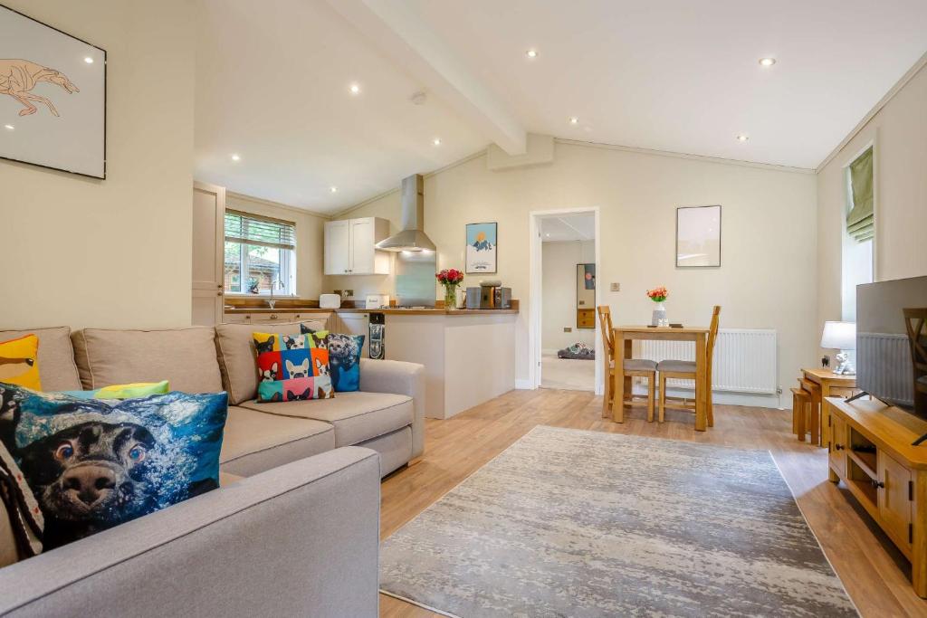 a living room with a couch and a table at Campden Lodge 1 in Kingham