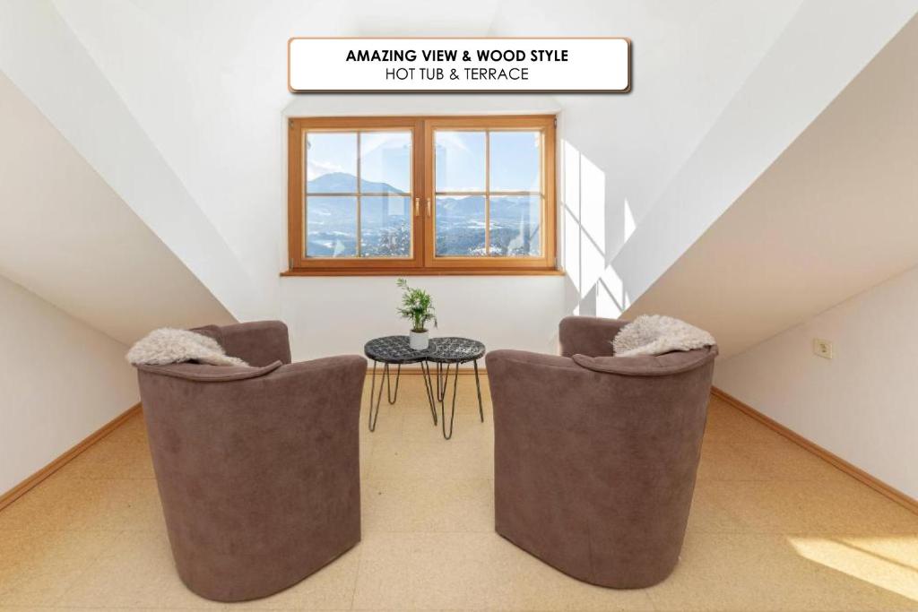 a attic room with two chairs and a table at Guest House Štruc in Slovenj Gradec