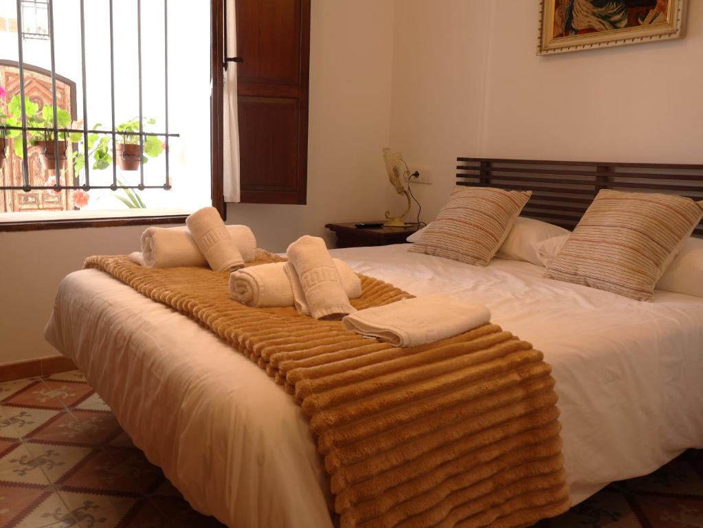 een groot bed met een deken erop bij Hotel 3* La Casona de las Flores in Ondara