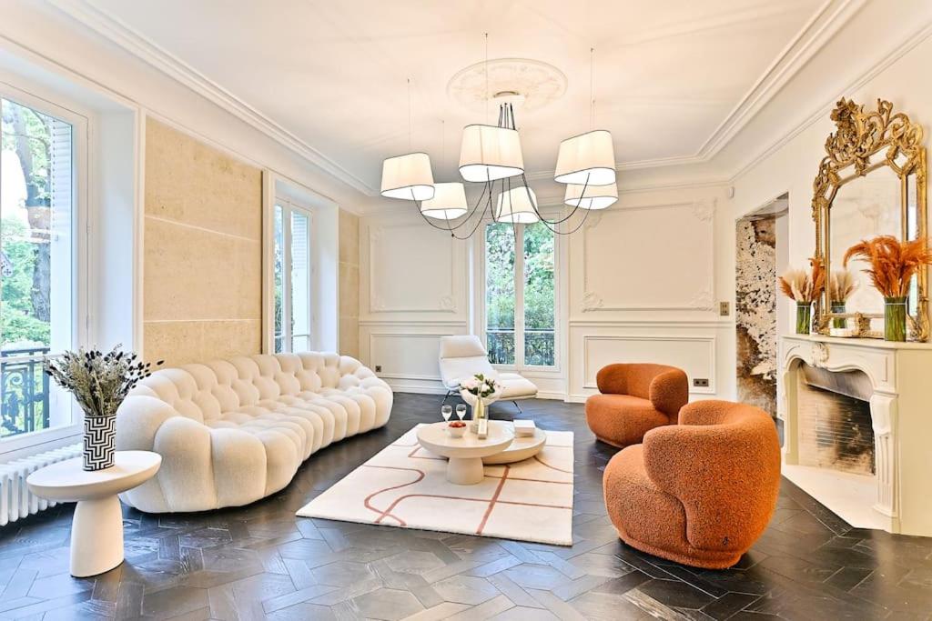 - un salon avec un canapé, des chaises et une cheminée dans l'établissement Appartement d'architecte luxueux Neuilly-sur-seine, à Neuilly-sur-Seine