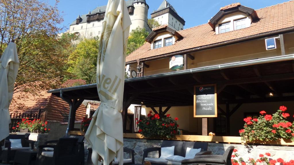 a restaurant with tables and umbrellas in front of a building at U Královny Dagmar in Karlštejn