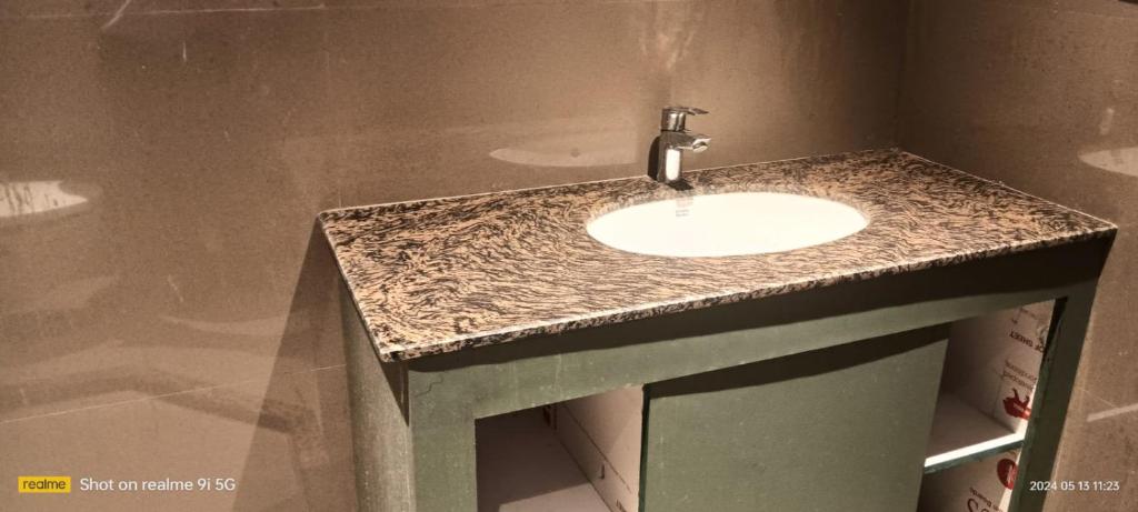 La salle de bains est pourvue d'un lavabo et d'un plan de travail en granit. dans l'établissement Manara Event, à Gwalior