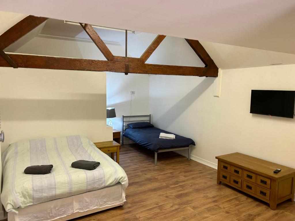 a bedroom with a bed and a table and a tv at The Diary in Takeley