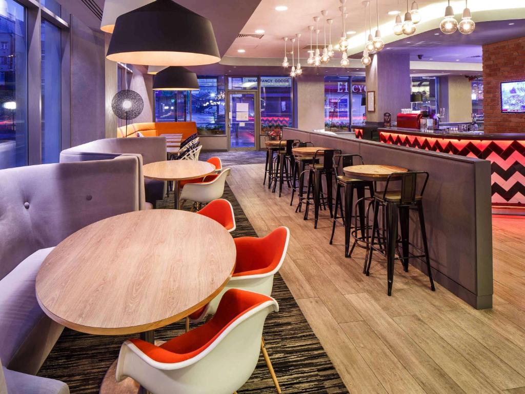 a restaurant with tables and chairs and a bar at ibis London City - Shoreditch in London
