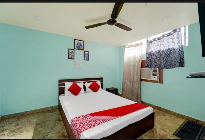 - une chambre avec un lit et un ventilateur de plafond dans l'établissement Hotel 27 degree, à Dhanbād