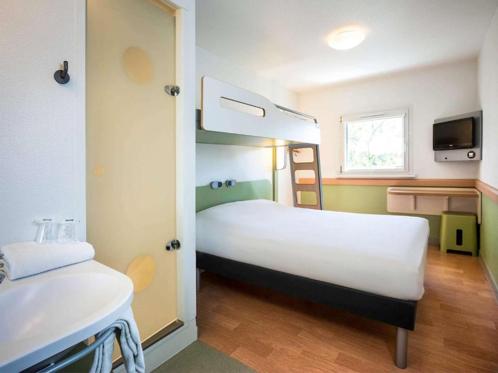 a bedroom with a bed and a bunk bed at Ibis Budget Sélestat in Sélestat