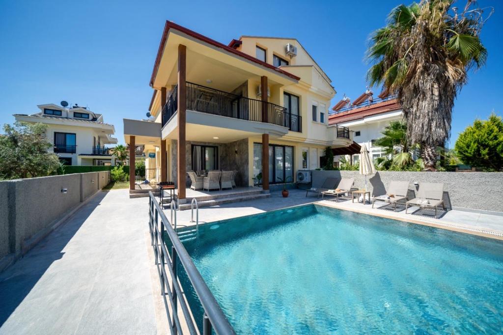 a villa with a swimming pool and a house at Villa Sorrento in Fethiye