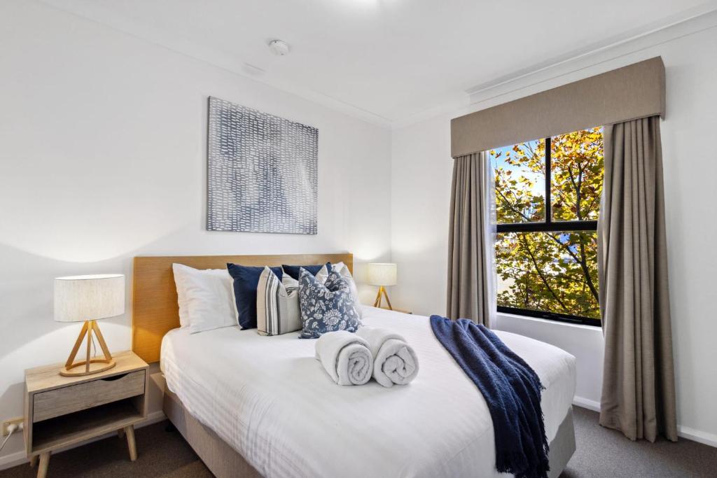 a bedroom with a large white bed with towels on it at Northbridge Hideaway 2BDR 1BTH in Perth