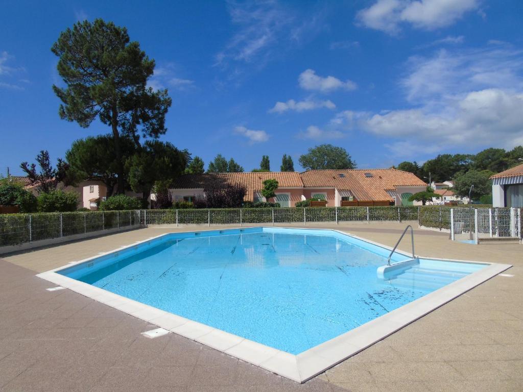 une grande piscine dans une cour dans l'établissement Le Mas de Vertmarines, à Saint-Jean-de-Monts