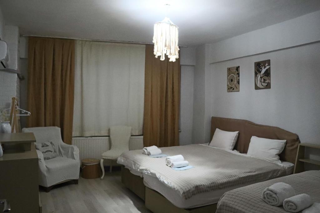 Habitación de hotel con 2 camas y lámpara de araña. en ERKUL OLD CITY, en Estambul