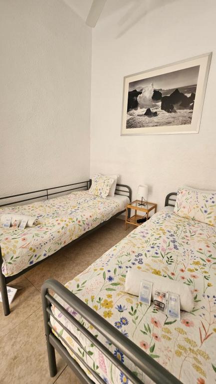Central and Basic Drassanes HOSTEL في برشلونة: غرفة نوم بسريرين وصورة على الحائط