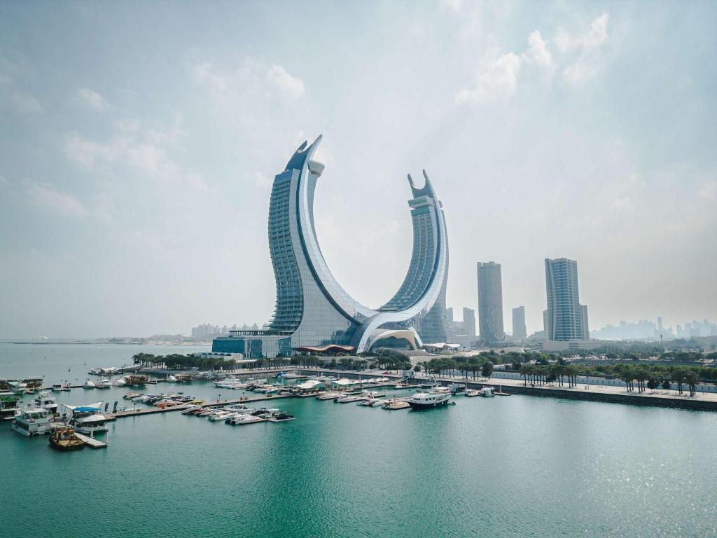 un gruppo di edifici con imbarcazioni in una cassa d’acqua di Raffles Doha a Doha